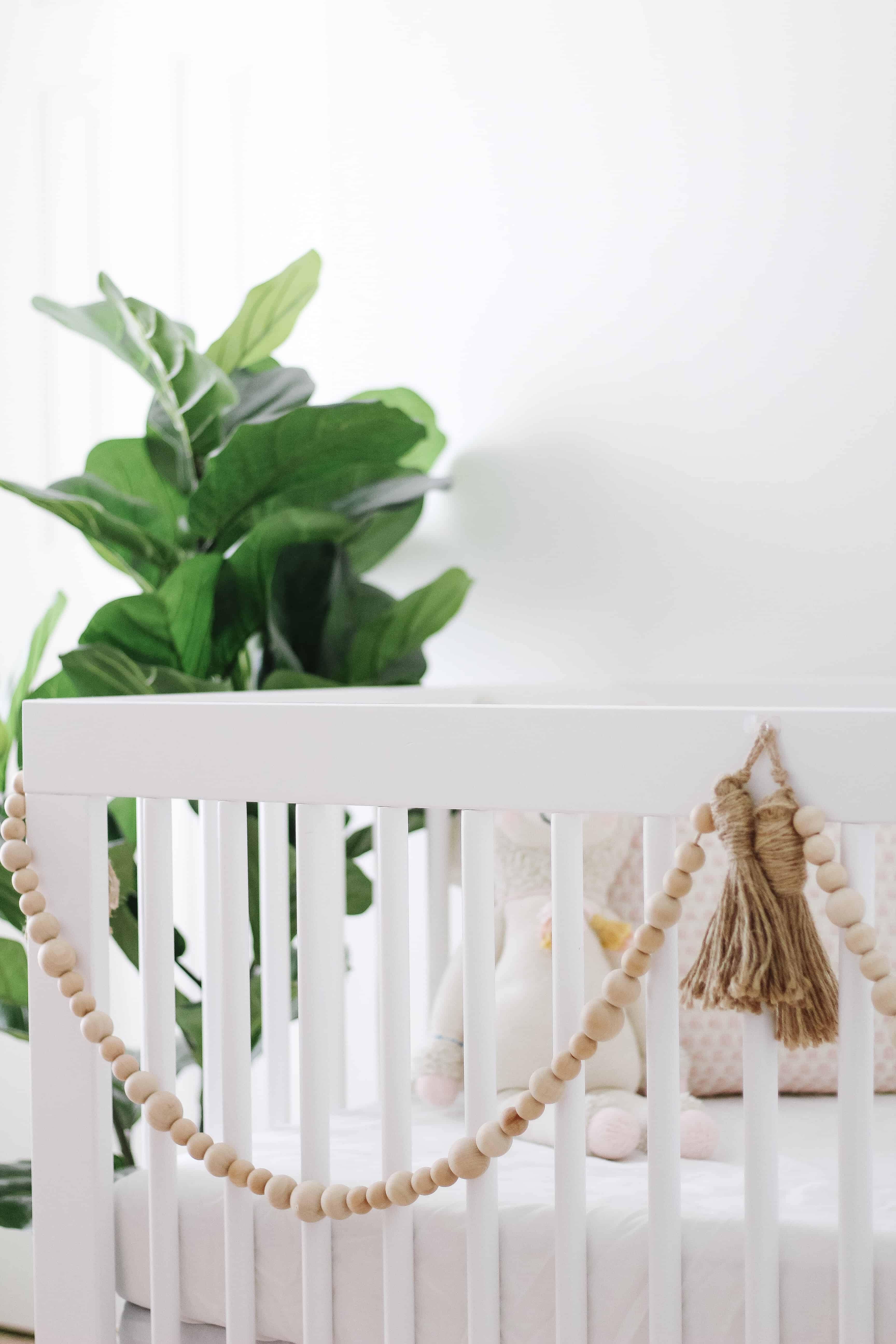 white crib with wood beads