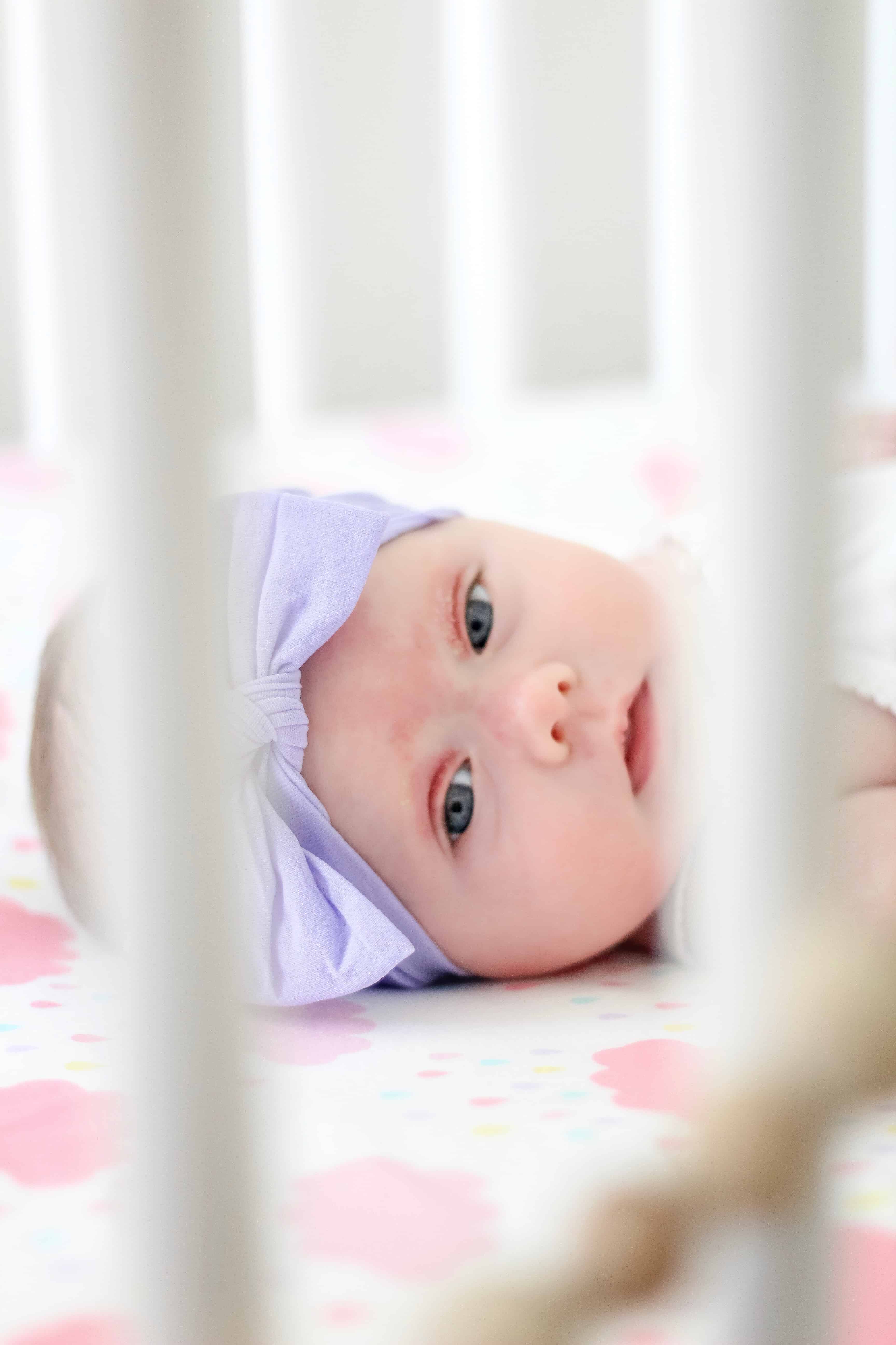 baby girl in purple headband on walmart sheet