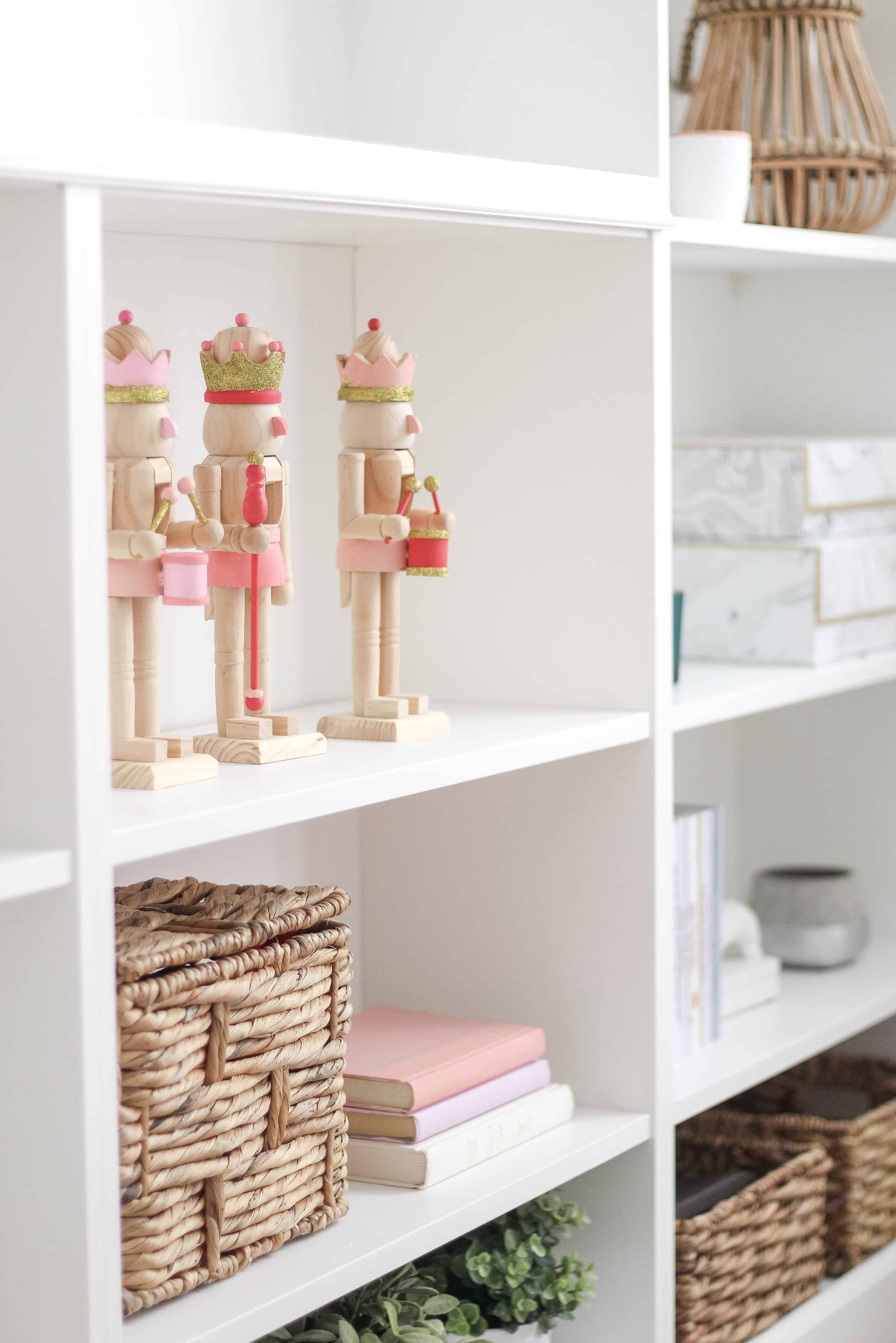 pink and gold wood nutcrackers on built in shelving