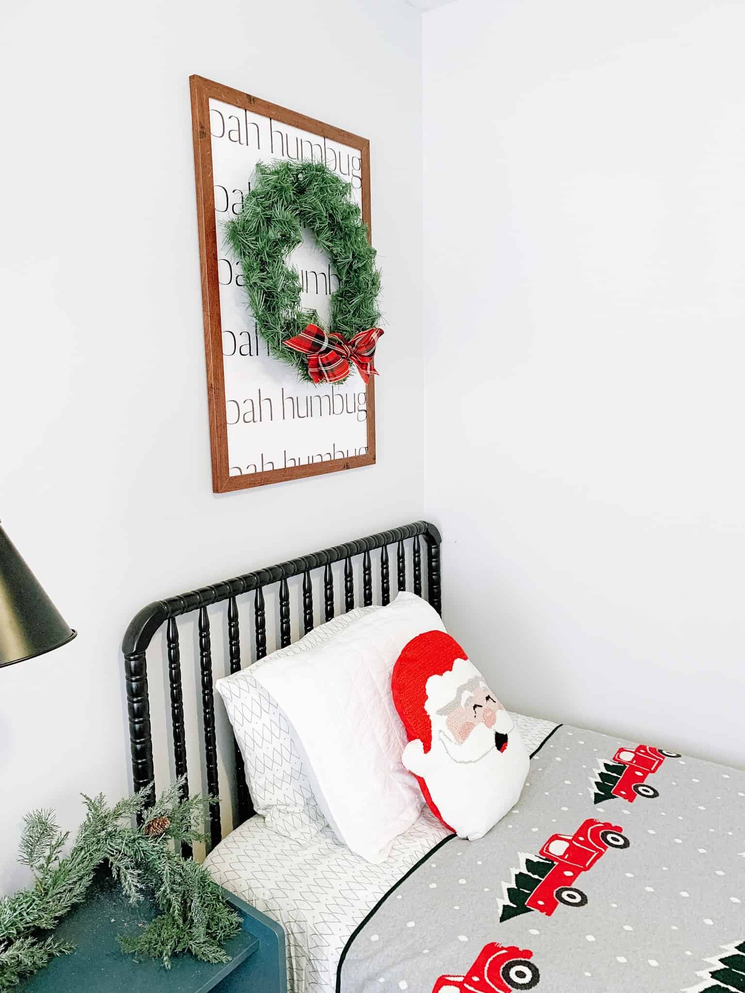 Boys bed with wreath over it and Santa pillow for Christmas