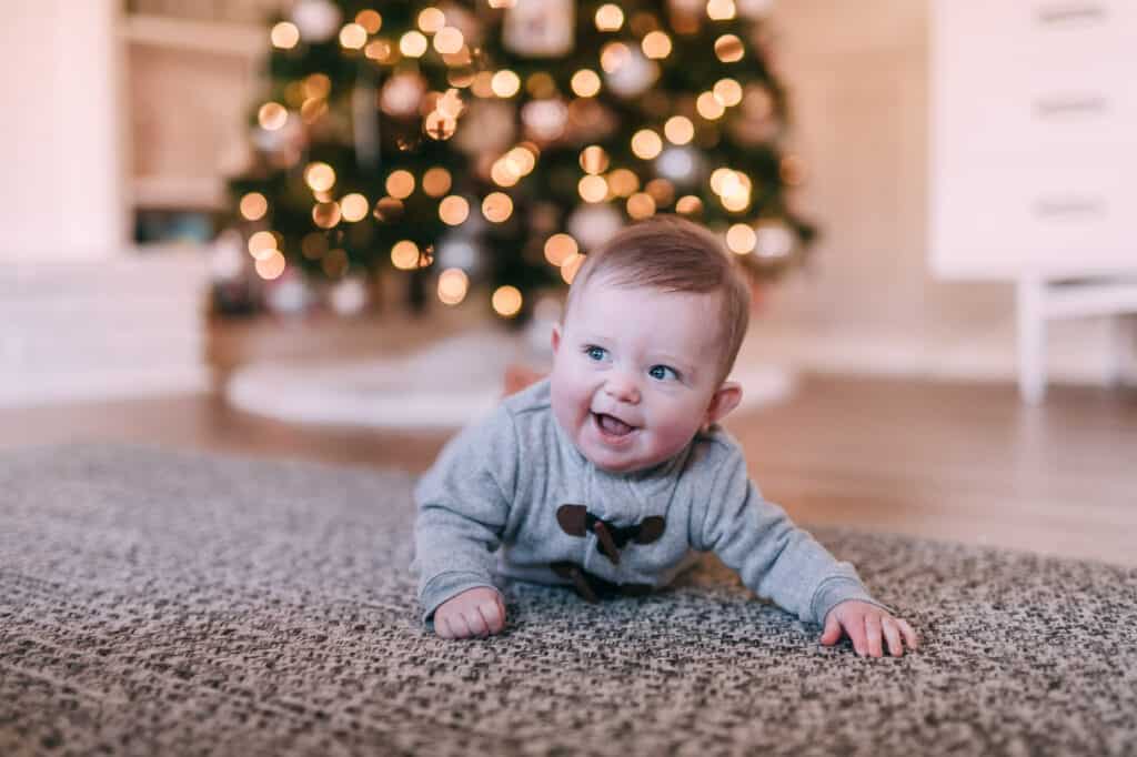 baby boy in front of Christmas Tree