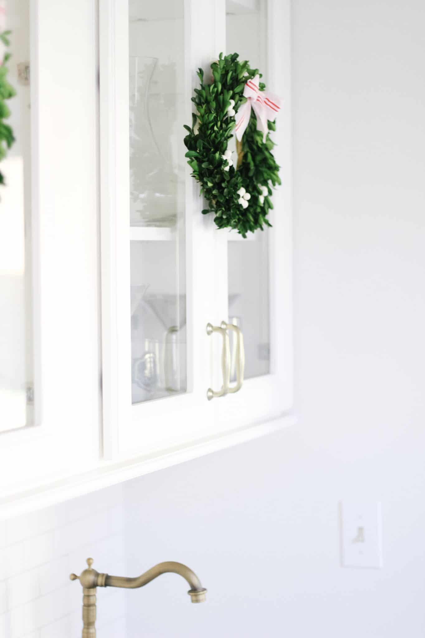 Boxwood Wreaths on white cabinets