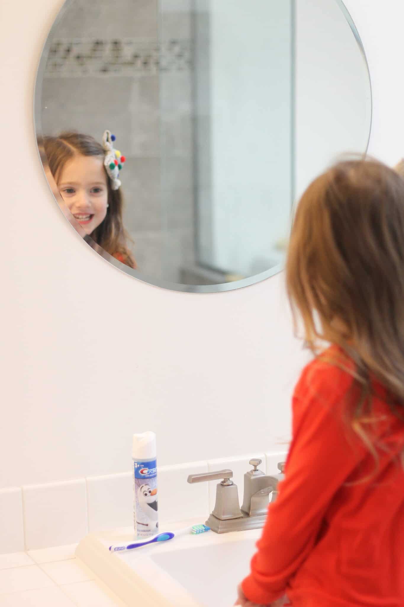 little girl brushing her teeth with Crest