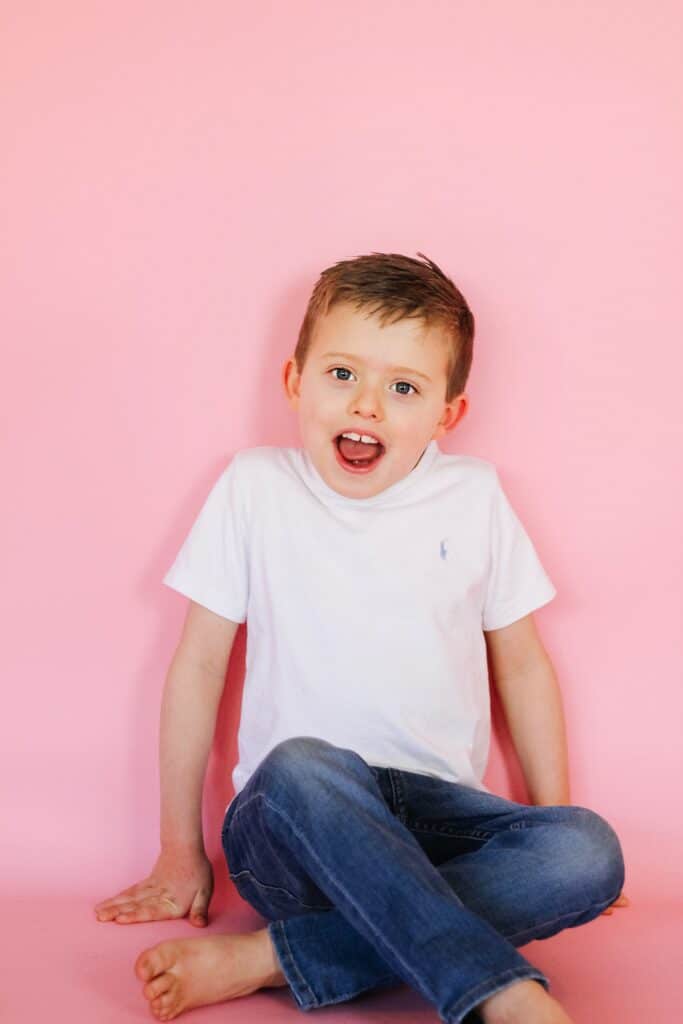 little boy against pink backdrop