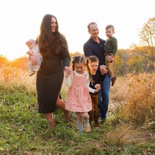 Family walking through field for family photos