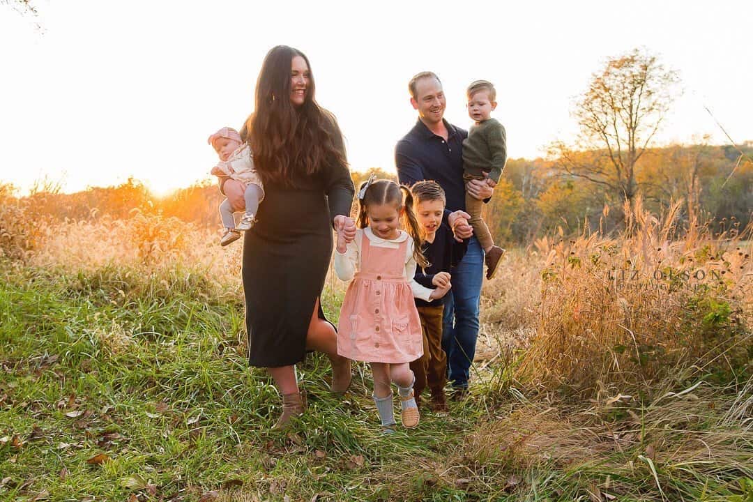 Family walking through field for family photos