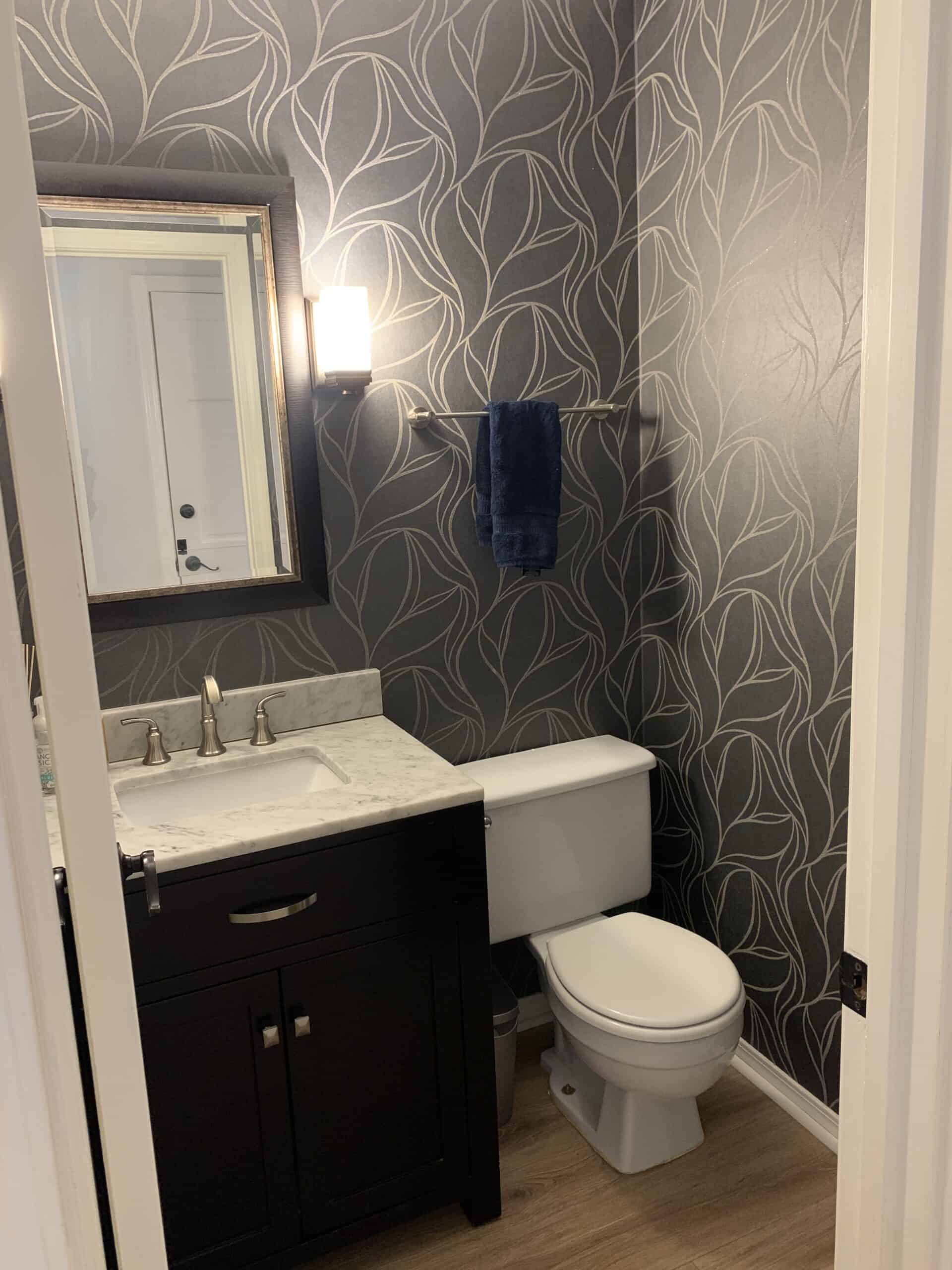 Powder room with navy blue and silver wallpaper