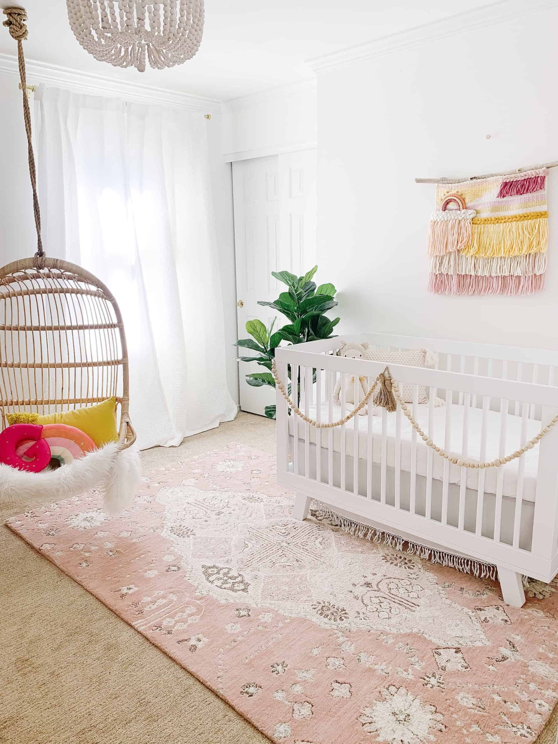 Boho pink nursery with hanging Serena and Lily Rattan Chair