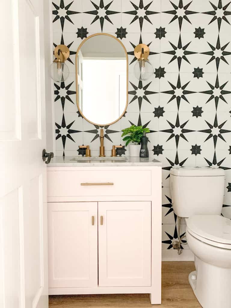 Bold pink powder room with black and white tile wall
