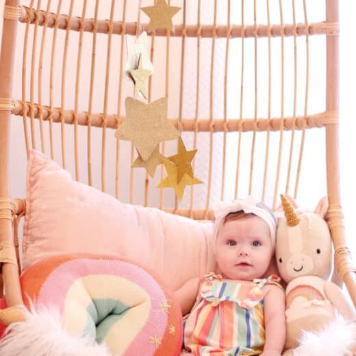 baby girl in hanging Serena and lily chair