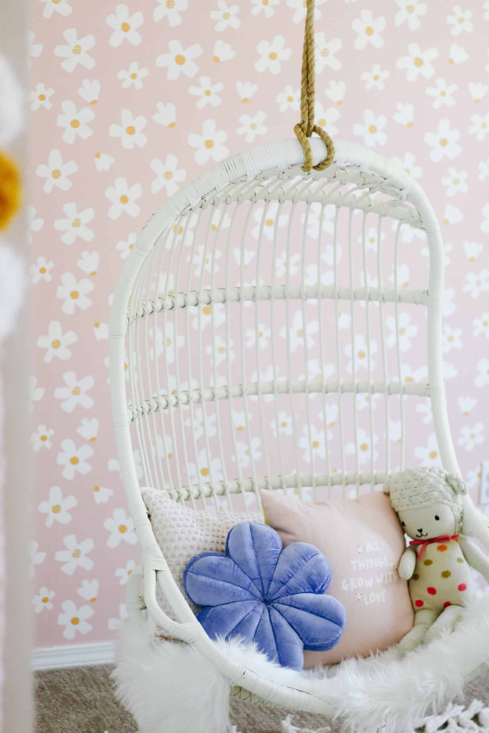 hanging chair in front of daisy wallpaper