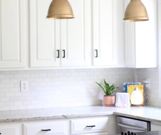 gold lights and black handles from amazon in white kitchen