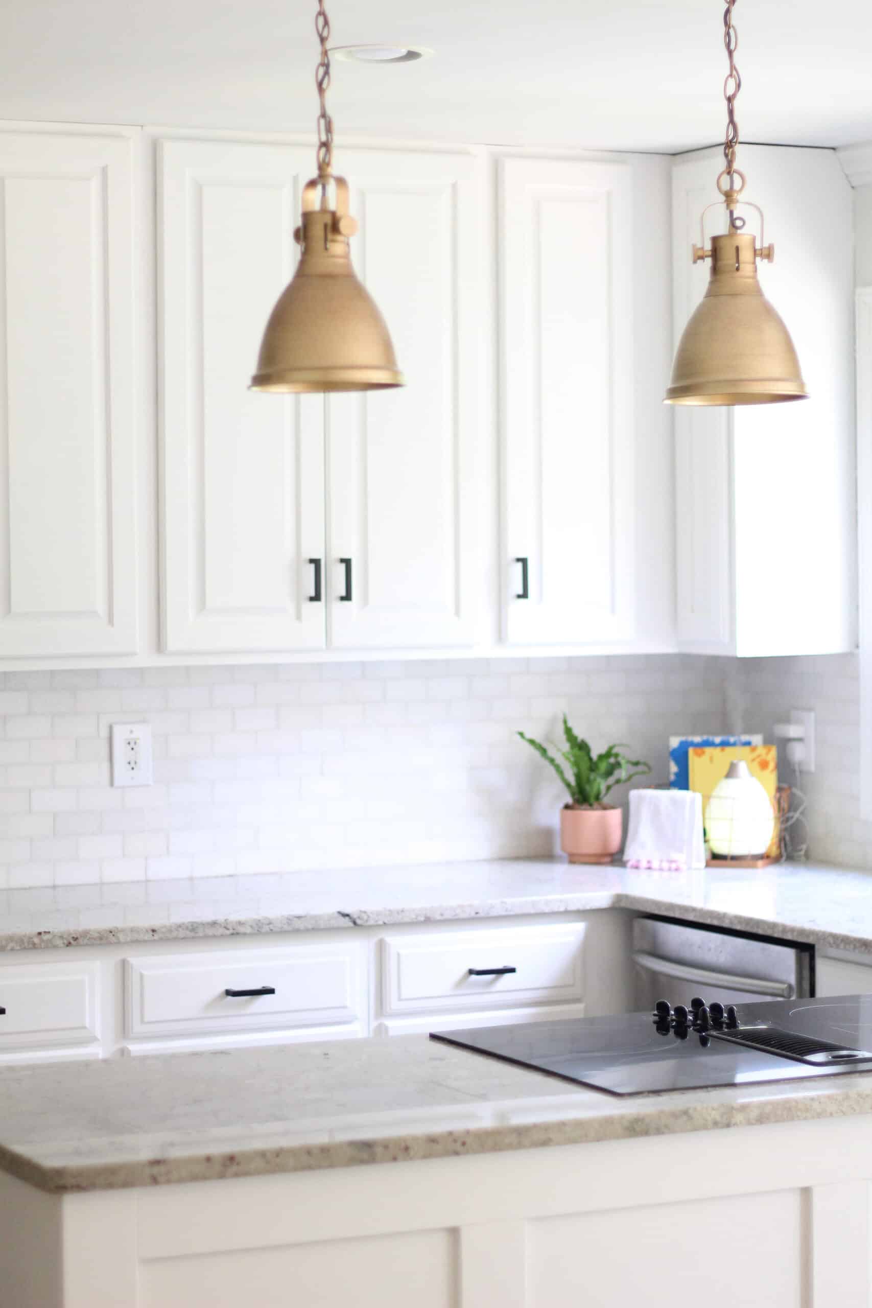 gold lights and black handles from amazon in white kitchen