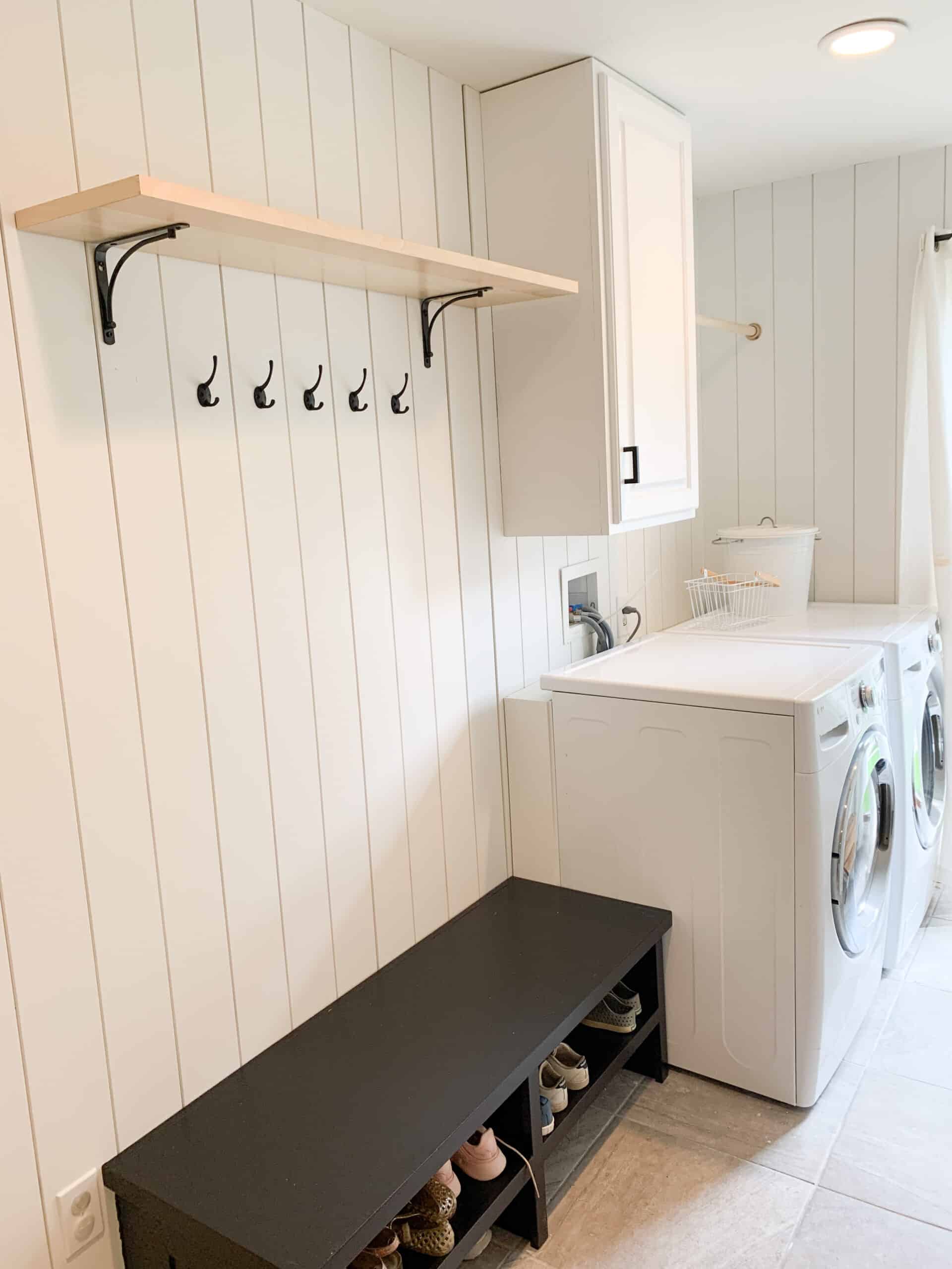 black bench in laundry room with mudroom