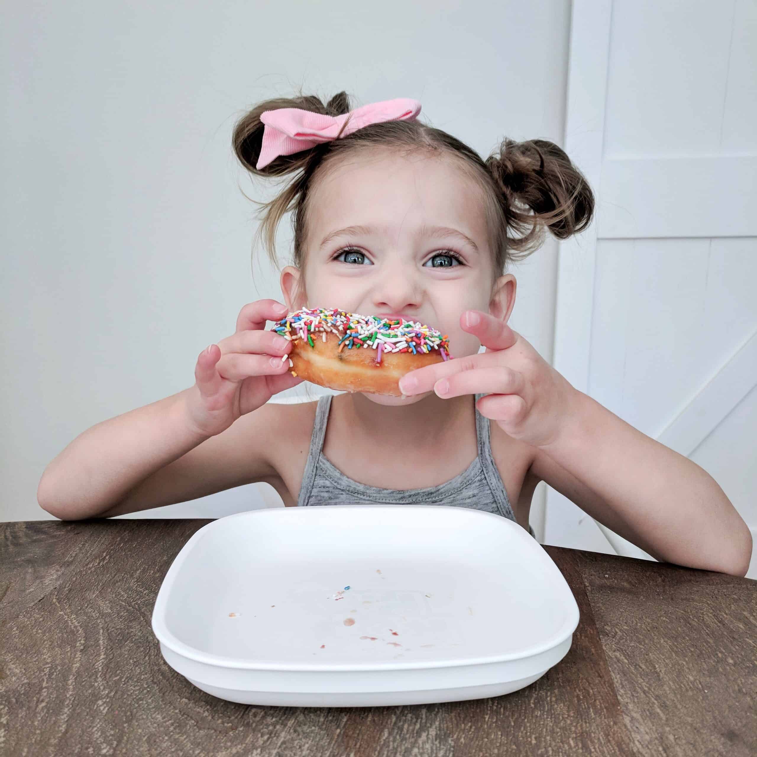 little girl eating a donut