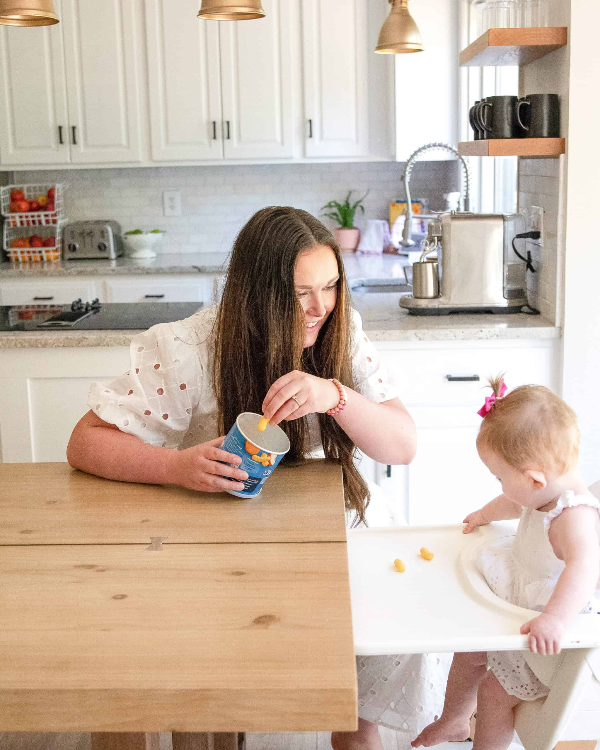 mom feeding baby Gerber Puffs