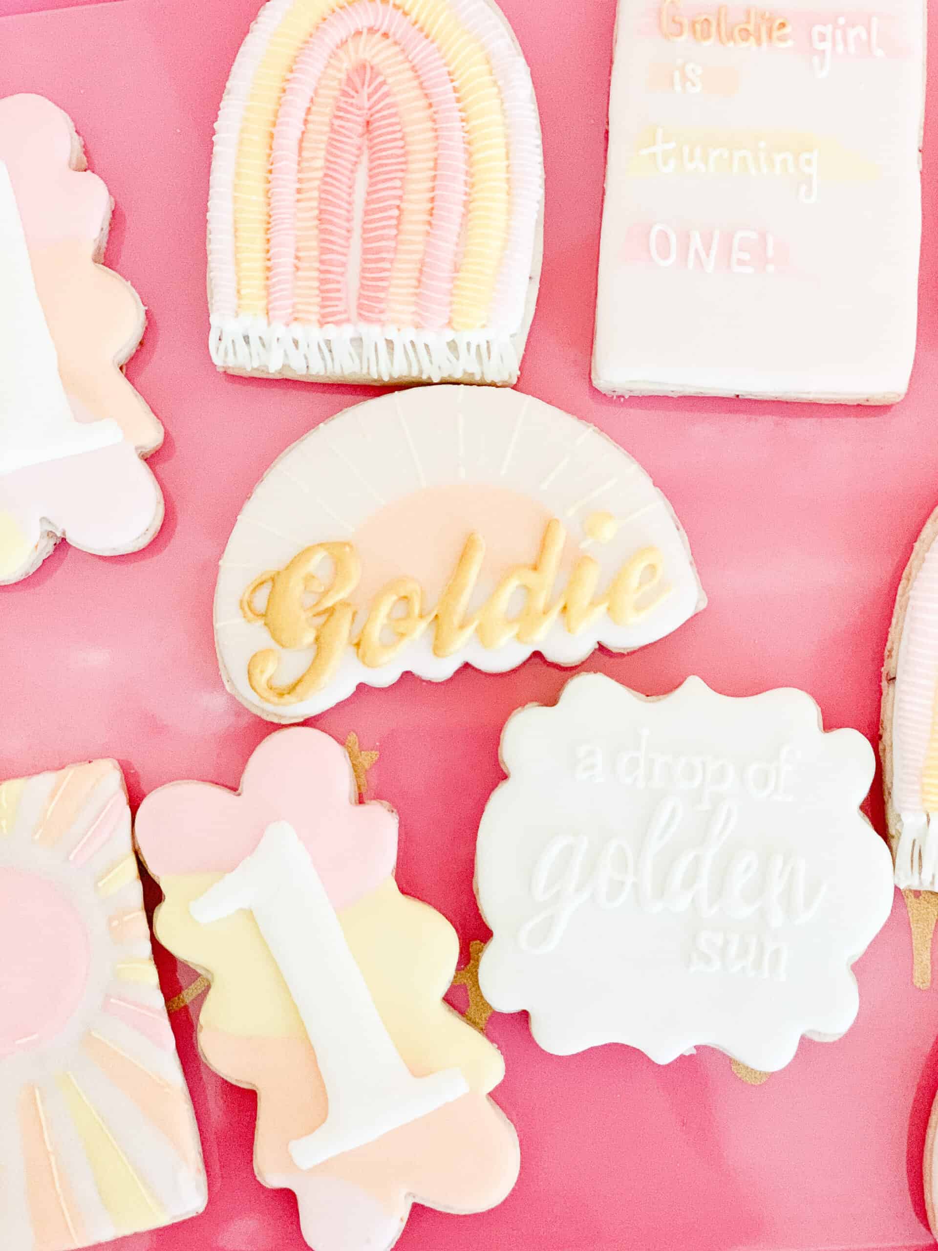 pink yellow and white birthday cookies with sunshines and rainbows