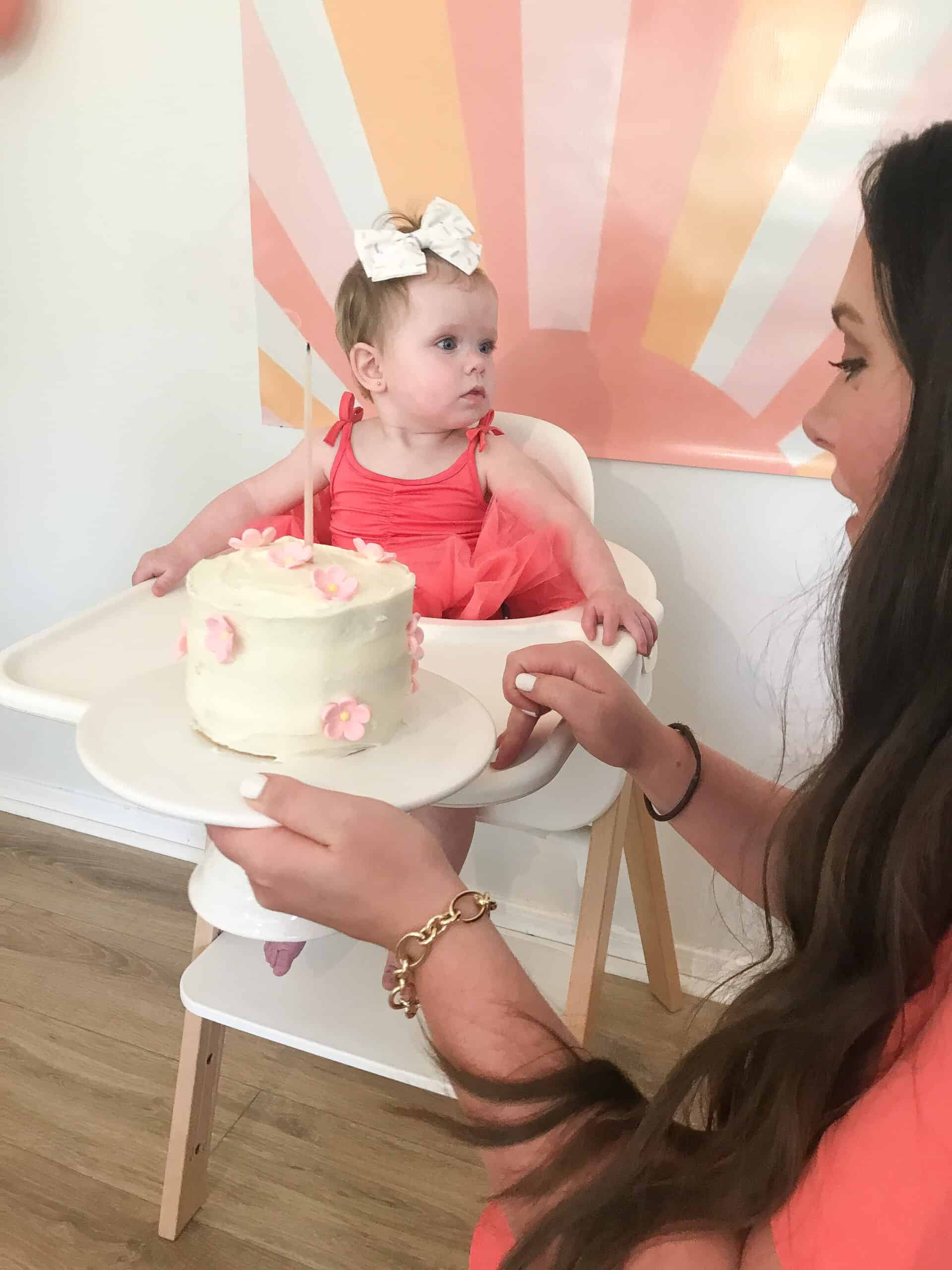 Baby girl with her pink flower smash cake