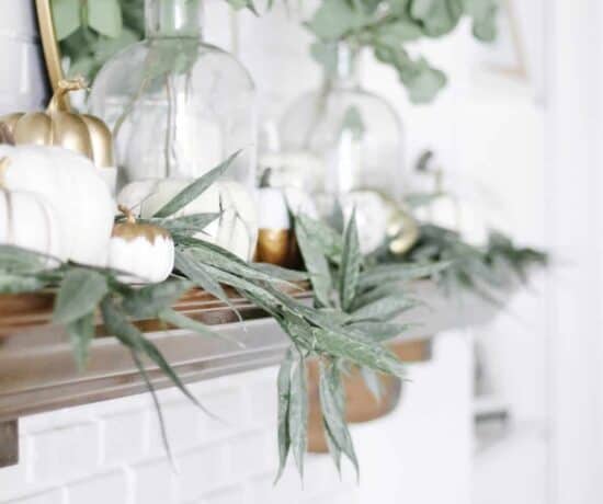 fall mantle decor that is white pumpkins and greenery