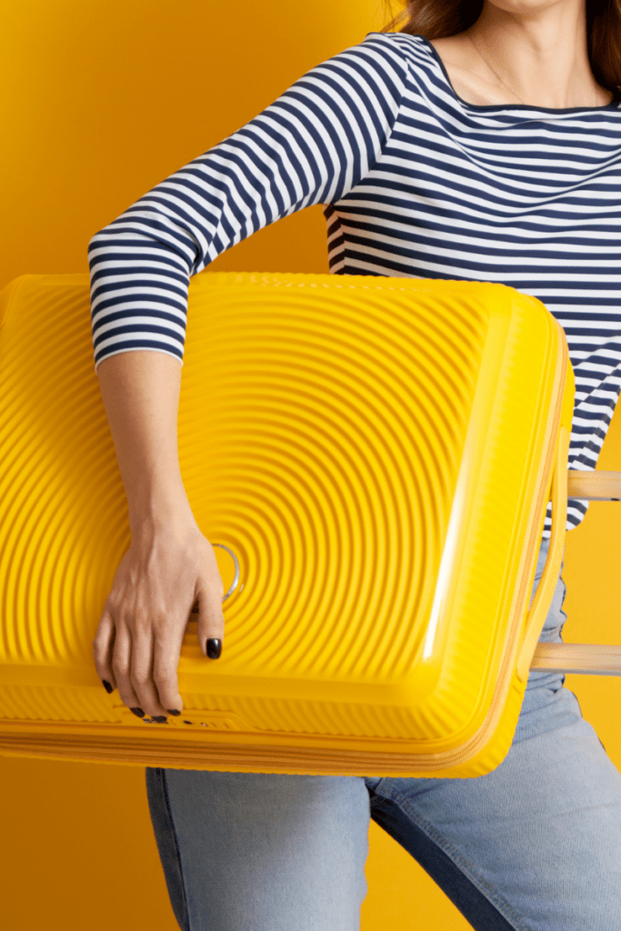 woman carrying yellow suitcase