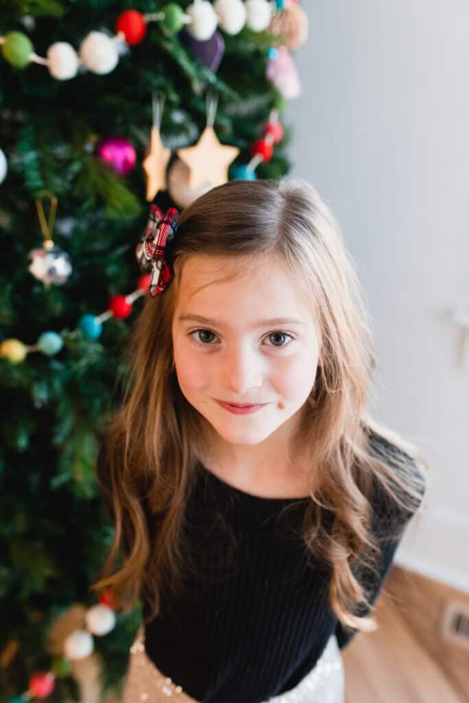 6 year old girl by Christmas tree