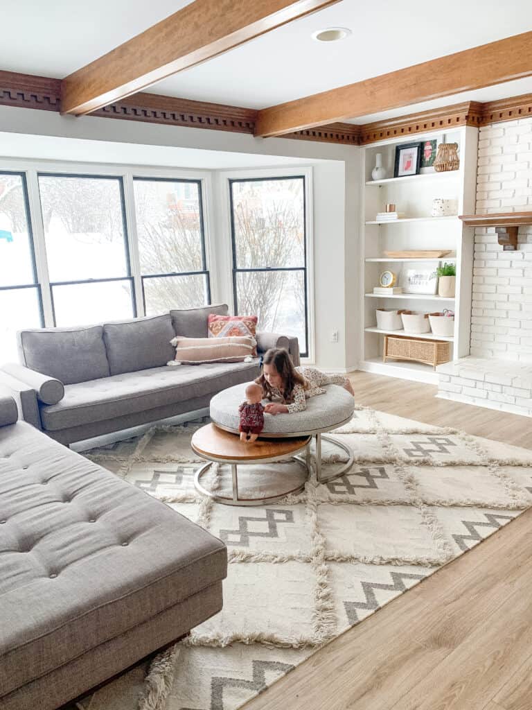 little girl on ottoman at house