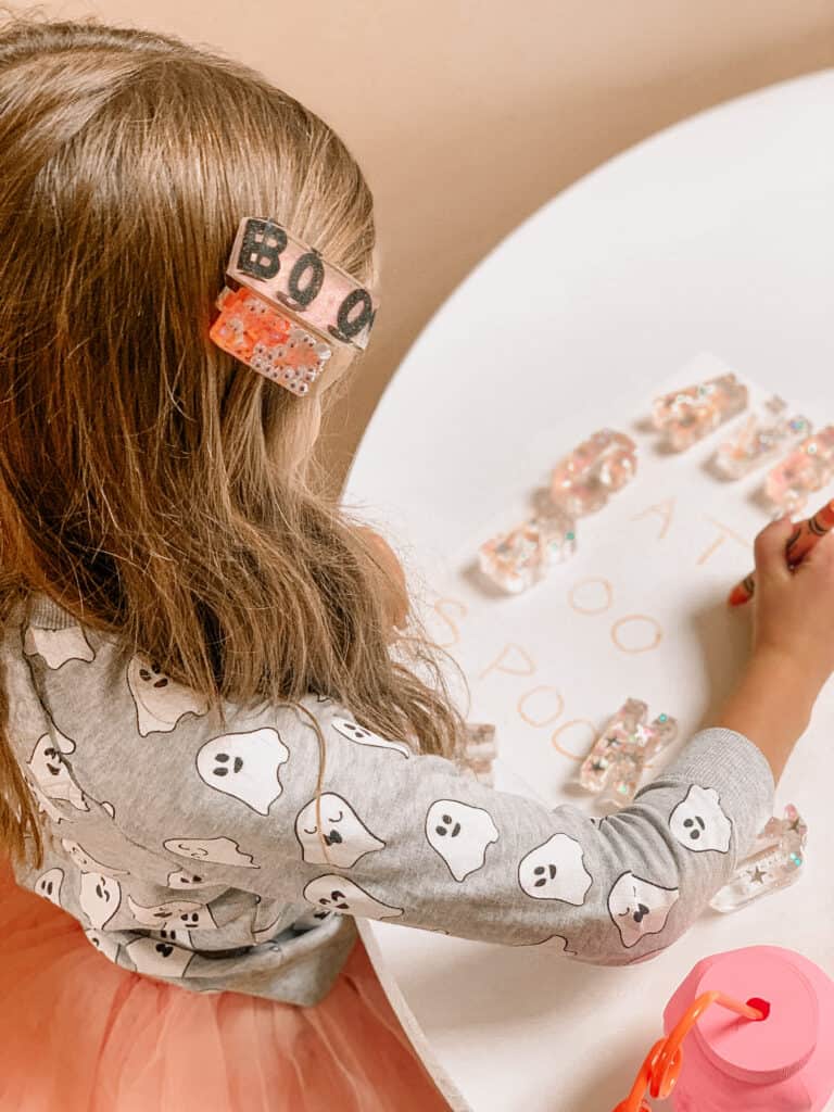 little girl doing halloween activity with resin letters