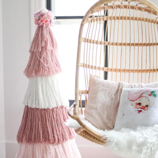DIY Pink yarn Christmas tree next to Serena and lily chair