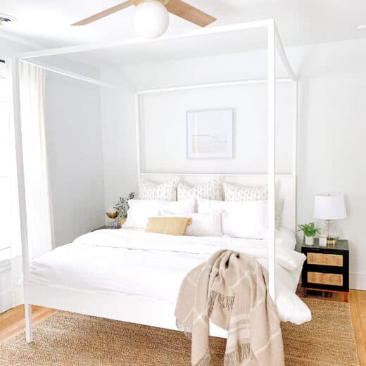 master bedroom with white bedding and white canopy bed