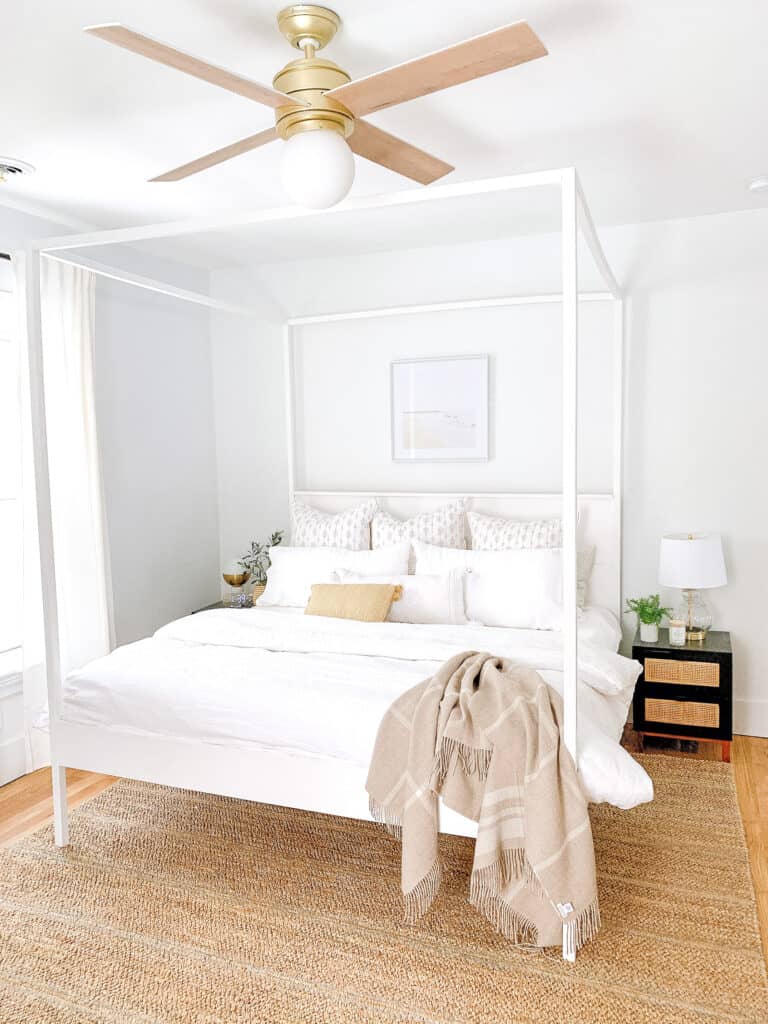 master bedroom with white bedding and white canopy bed