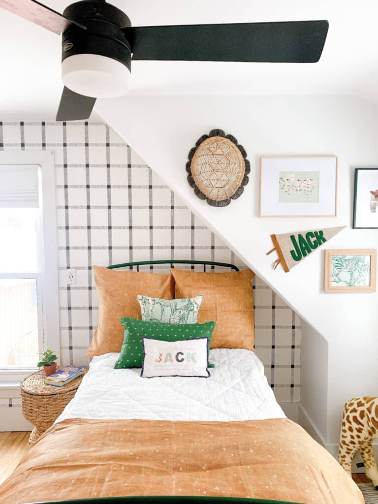 boys green bed against black and white wallpaper wall with green and tan bedding 