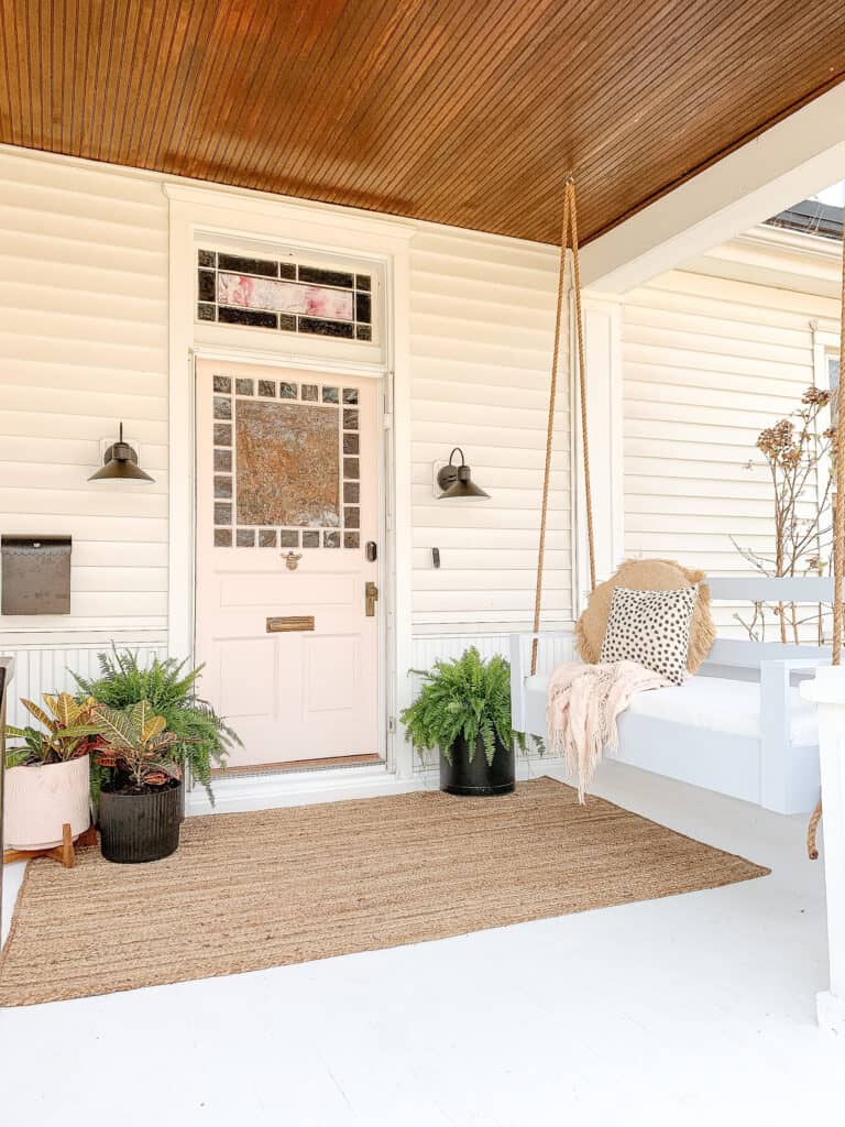 pink door on porch with porch swing