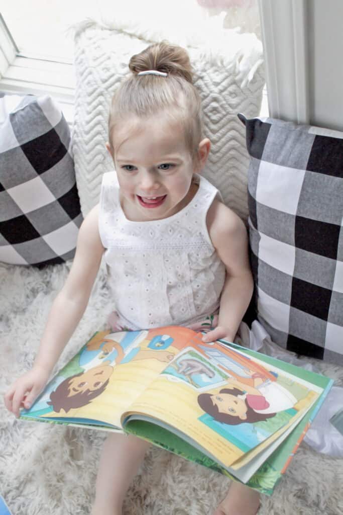 Toddler girl reading book 