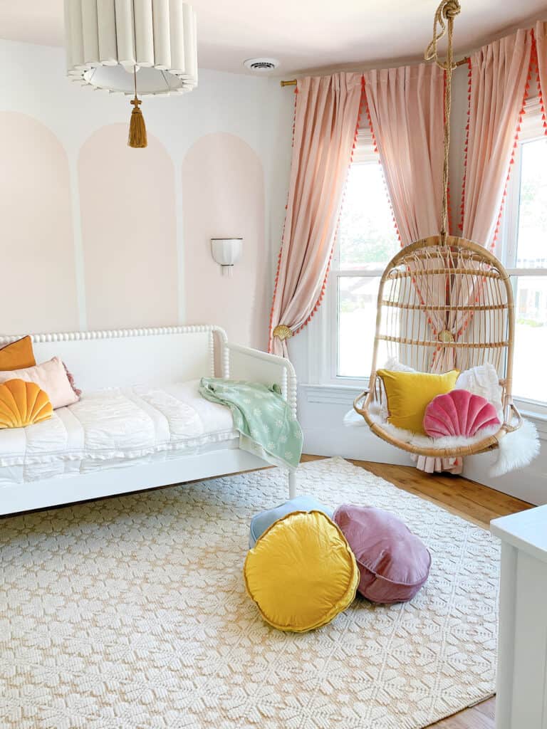 room with blush pink arches and hanging chair 