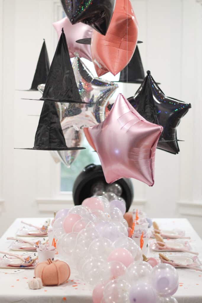 Pink stars and witch hats over table 