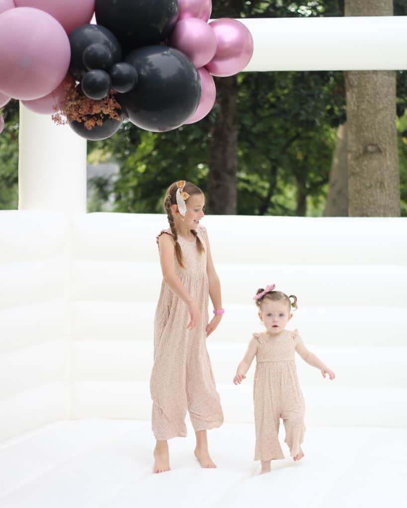 Siblings on white bounce house