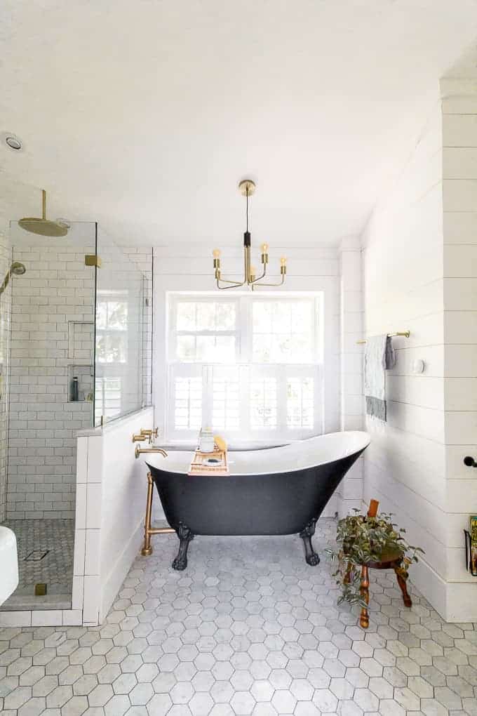 black clawfoot tub in marble bath