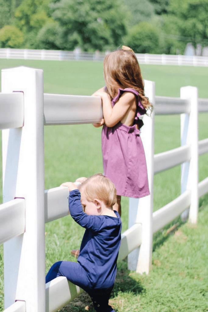 kids by horse riding fence