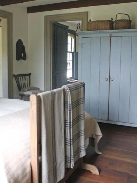 Powder blue antique chest with a wooden natural blanket ladder.