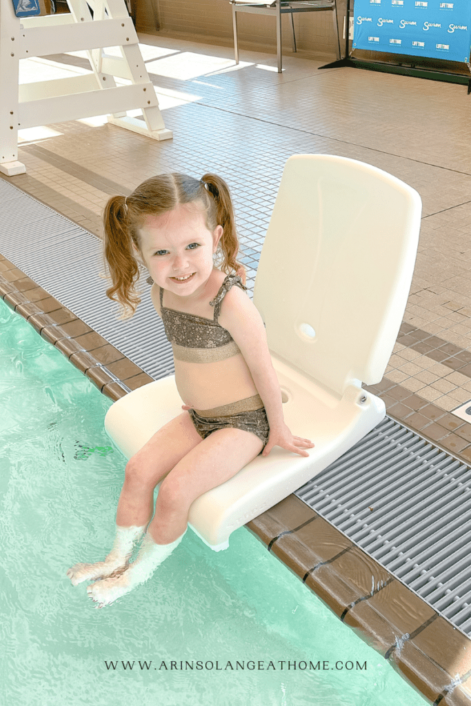 girl sitting in poolside chair 