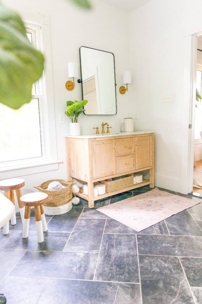 Wooden natural bathroom vanity, pink rug.