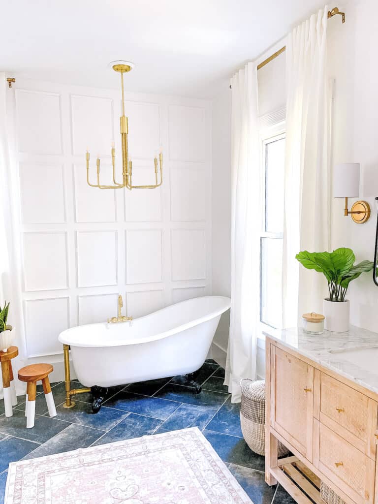 Master bathroom with clawfoot tub in front of a picture frame molding wall.