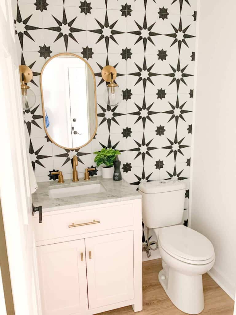 Pink powder bathroom vanity with black and white geometric star tiles.