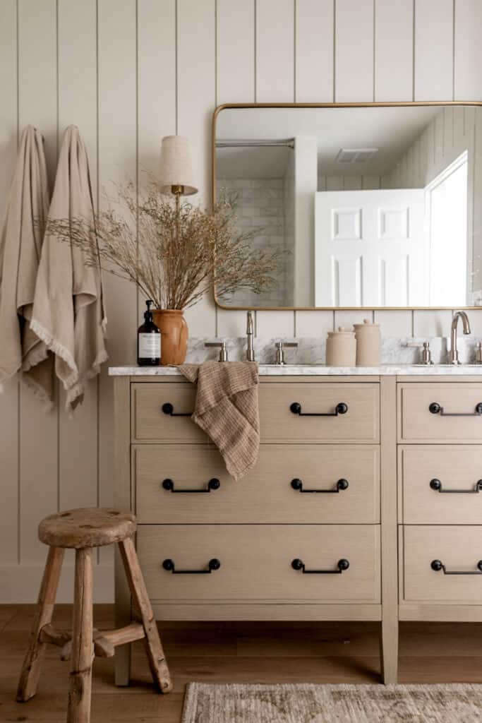 Taupe bathroom with gold and black accent hardware.