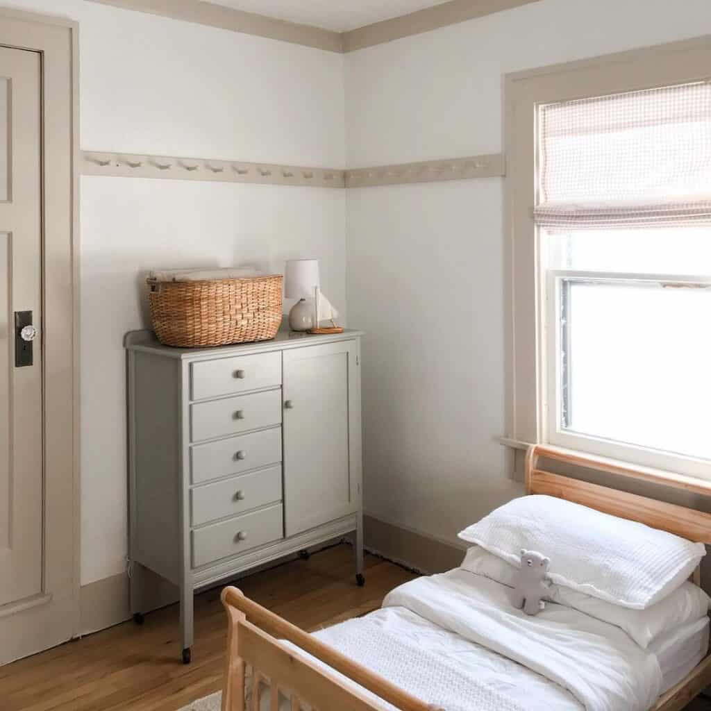 Child's bedroom with simple white bedding and natural wooden decor.