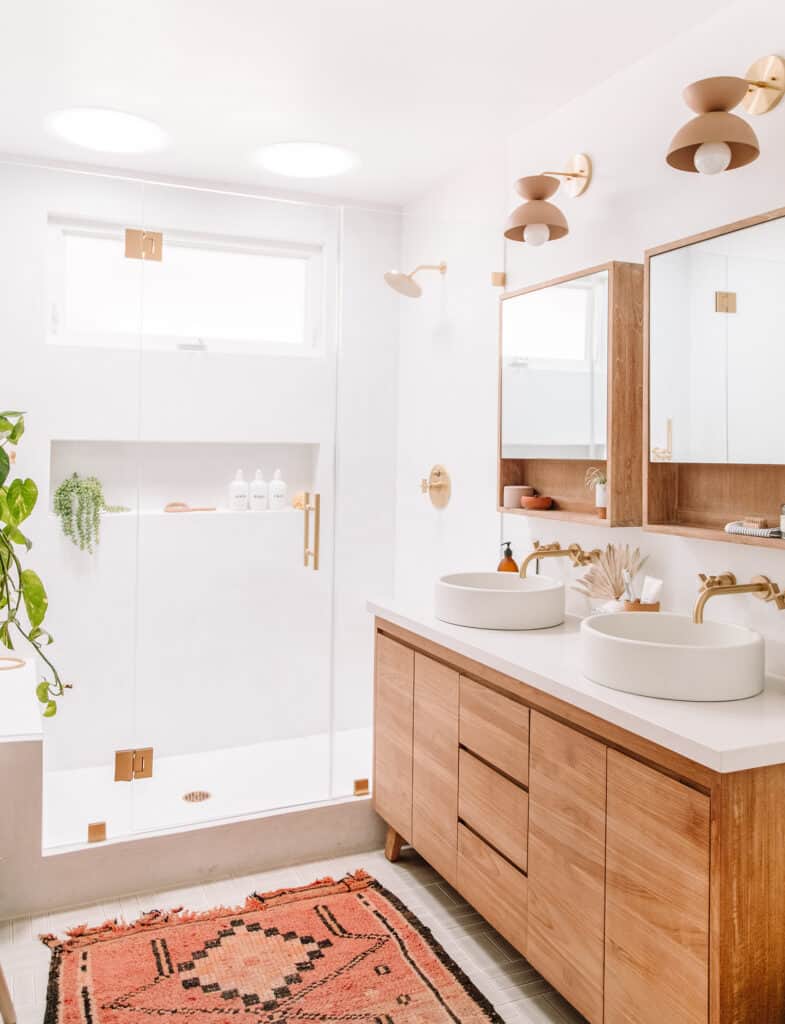 Natural wooden bathroom with a large walk in shower and greenery.