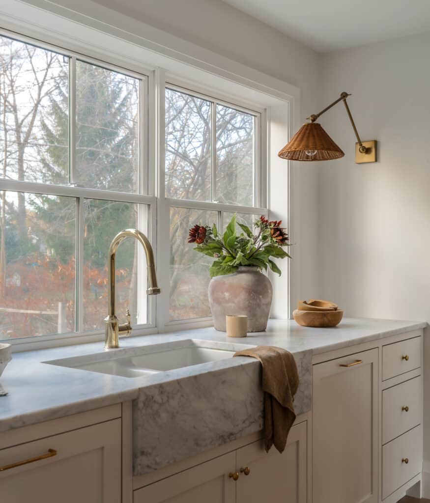 White kitchen with marbled front apron sink.