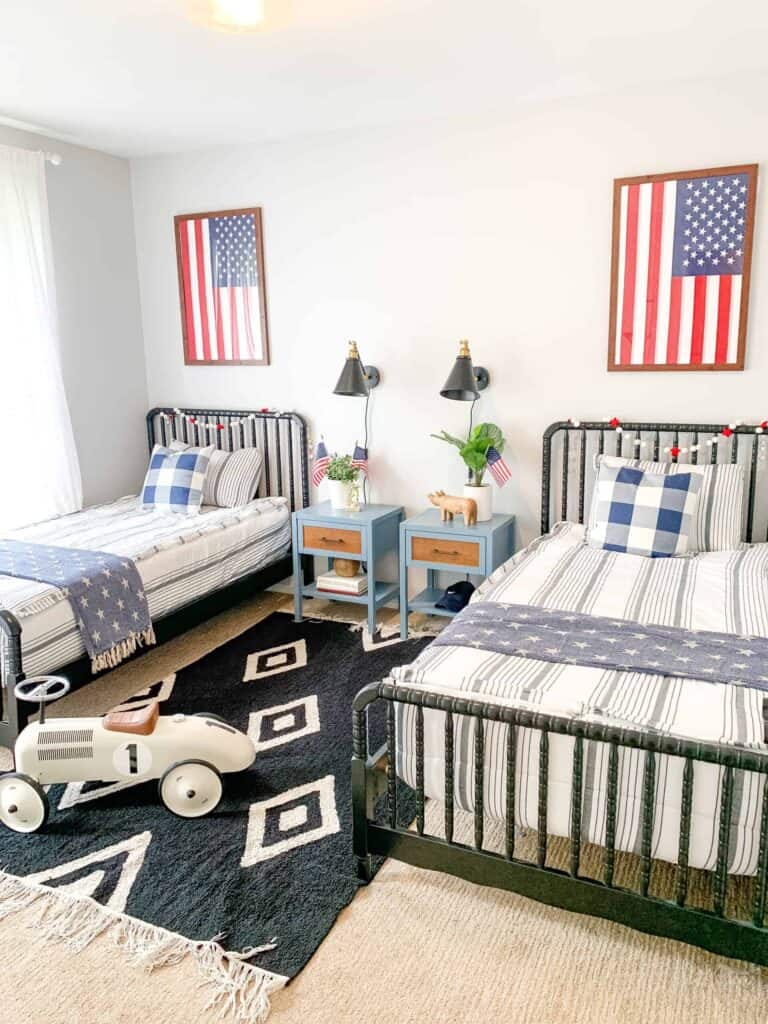 Boys shared room with two twin Linden beds and American flags hanging above bed.