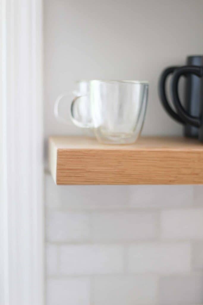 Close up of floating shelf and glass.