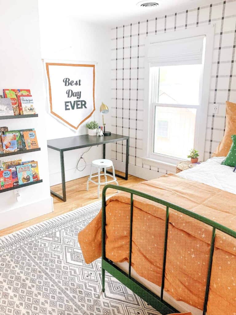 Boys room with white and black plaid wallpaper and black desk.